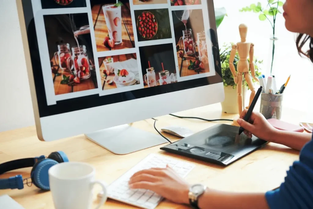 A woman focused on her computer, writing with a pen, and enjoying a cup of coffee beside her.